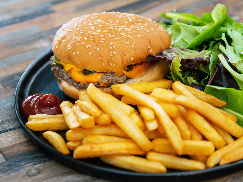 Cheeseburger and french fries with a side salad.